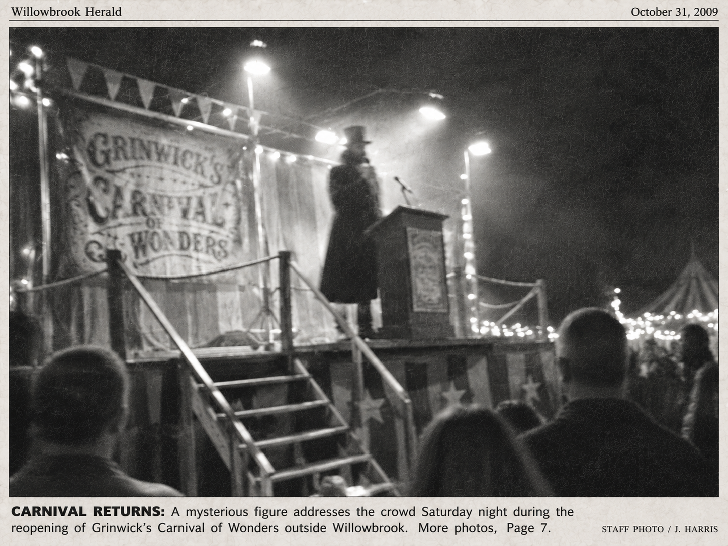 Blurry newspaper-style photograph of a raised carnival platform at night.